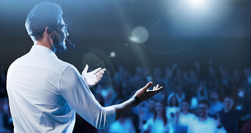 Motivational speaker with headset performing on stage